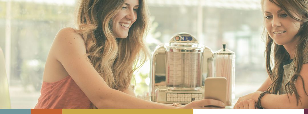 A smiling woman interacting with a vintage jukebox.