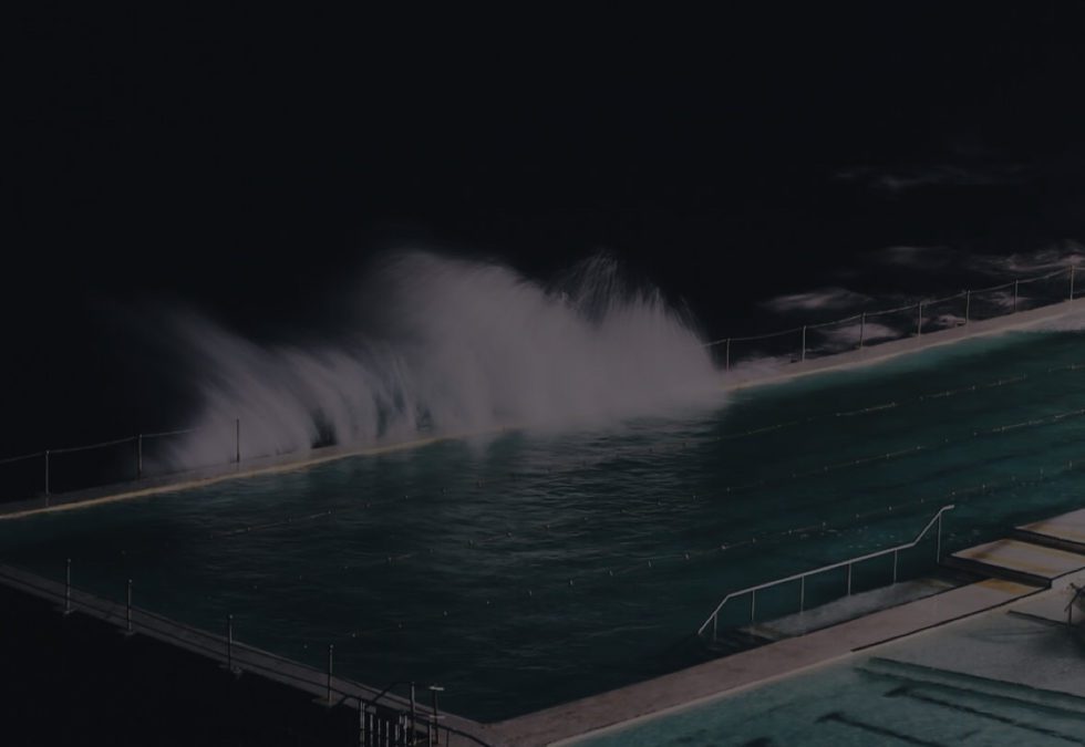 Ocean waves crashing near a dark pool at night.