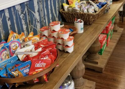 A wooden display table filled with various snacks, drinks, and condiments.